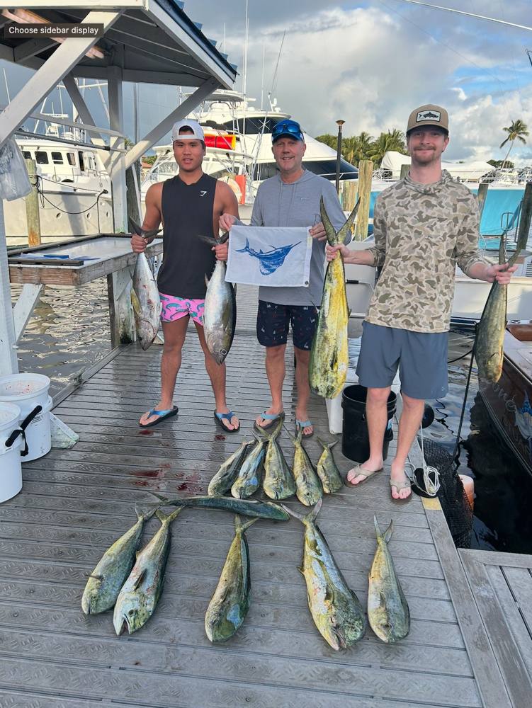 Guests with a mahi catch laid out on the dock