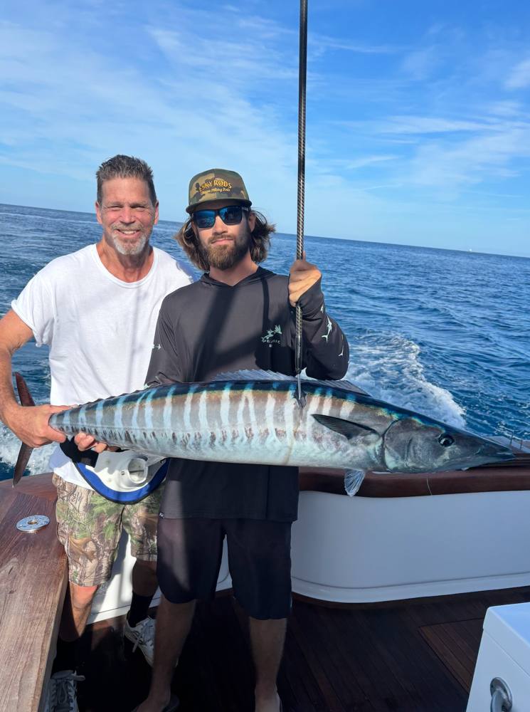 Two anglers holding a wahoo